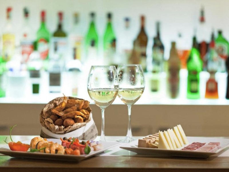 Aperitivo con stuzzichini e vino bianco ligure