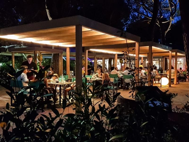 Veranda in mezzo al verde con persone che cenano