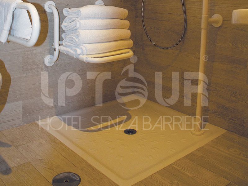 Doccia filo pavimento con barre e seduta, accessibile in sedia a rotelle